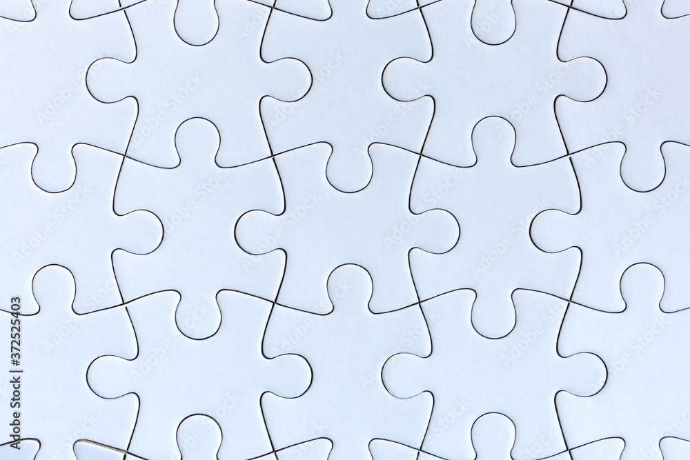 White jigsaw puzzle pieces on gray background White jigsaw puzzle pieces on gray background