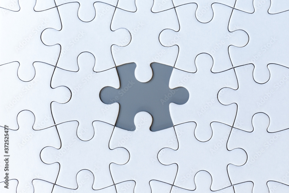 White jigsaw puzzle pieces on gray background White jigsaw puzzle pieces on gray background