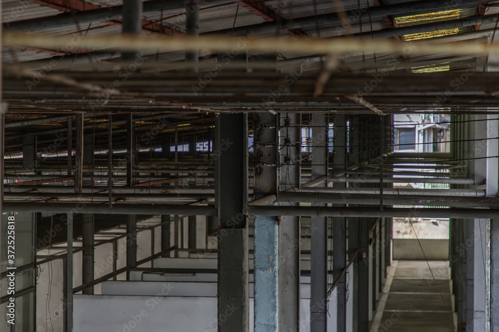 The structure inside the warehouse with light pole. Old structure in old building indoor. No focus, specifically.