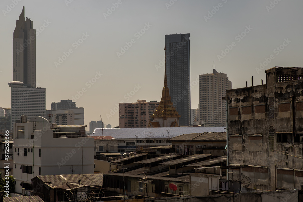 City view of Bangkok with Thai temple and modern tall buildings that perfectly coexist. No focus, specifically.