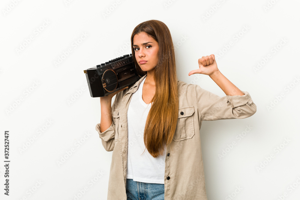 Young caucasian woman holding a guetto blaster feels proud and self confident, example to follow. Young caucasian woman holding a guetto blaster feels proud and self confident, example to follow.