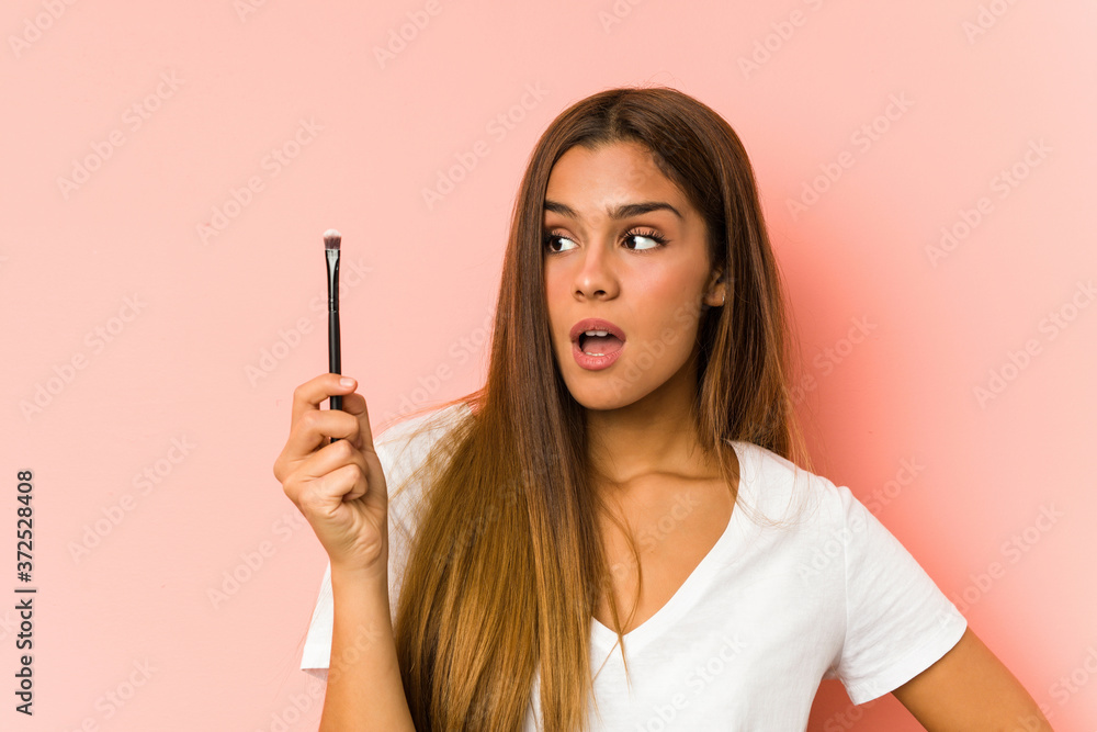Young caucasian woman holding a eyebrush isolated Young caucasian woman holding a eyebrush isolated