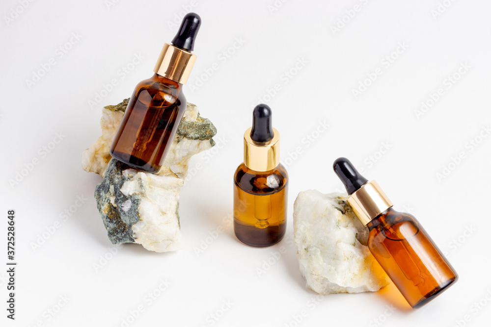Amber Bottle for essential oils and cosmetic products. Glass bottle on white background. A dropper, a bottle with a sprayer Amber Bottle for essential oils and cosmetic products. Glass bottle on white background. A dropper, a bottle with a sprayer