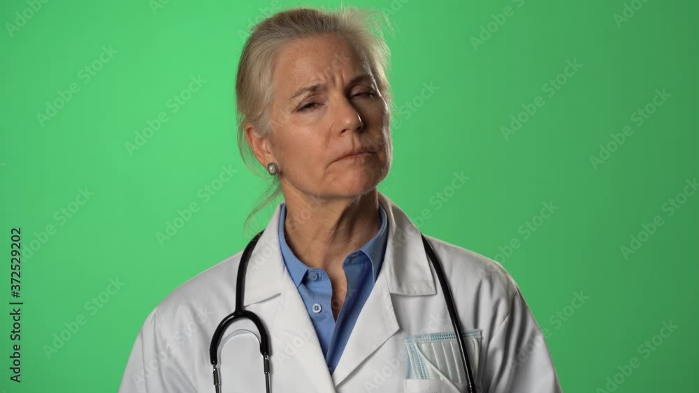 Push in portrait of experienced gray haired female doctor listening and talking to a patient. Shot on green screen. Push in portrait of experienced gray haired female doctor listening and talking to a patient. Shot on green screen.