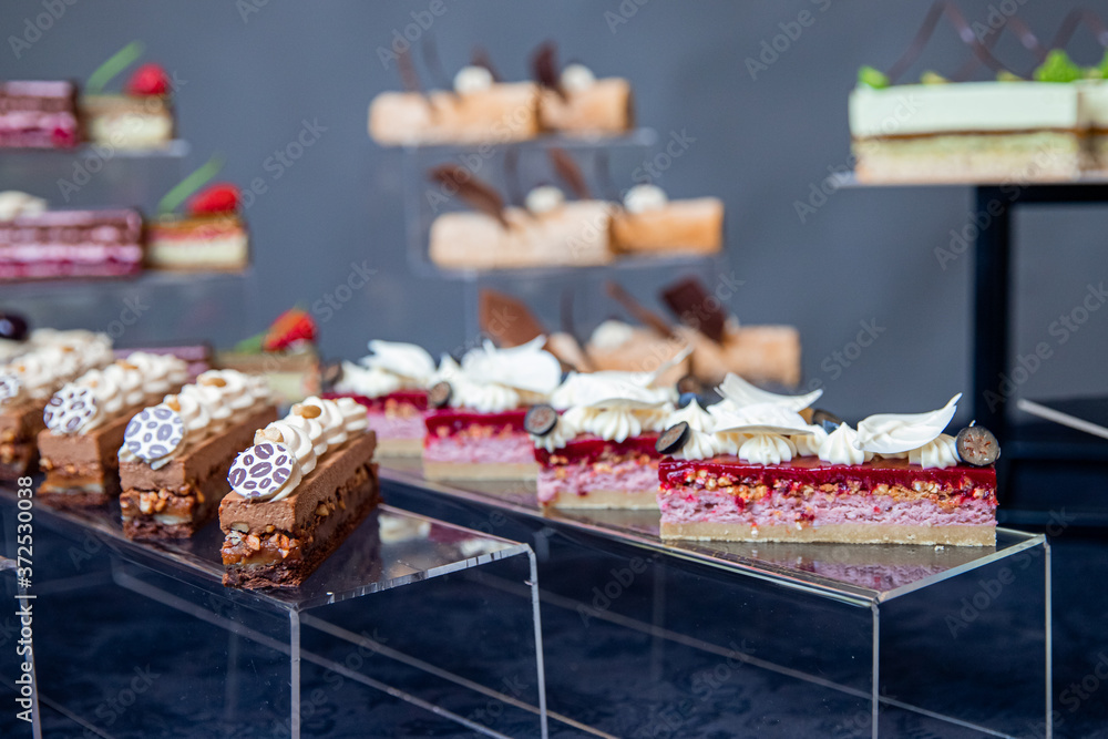 Sweet dessert table for catering and wedding with chocolate brownies and muscakes on dark background