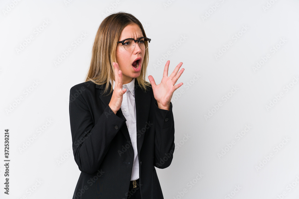 Young business caucasian woman shouts loud, keeps eyes opened and hands tense. Young business caucasian woman shouts loud, keeps eyes opened and hands tense.