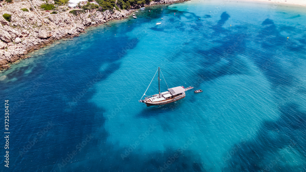 Aerial drone top down photo of pirates boat yacht with wooden deck anchored in open ocean sea