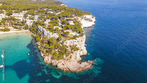 Beautiful aerial view of mediterranean bay with cliffs and holiday houses with swimming pools in Menorca, Spain Cala Galdana, aerial top view drone photo photo