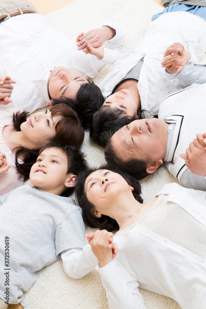 Obraz premium 笑顔で手を繋ぐ三世代ファミリー