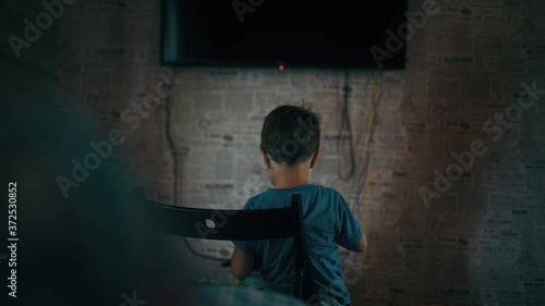 The boy plays on the phone and says something 