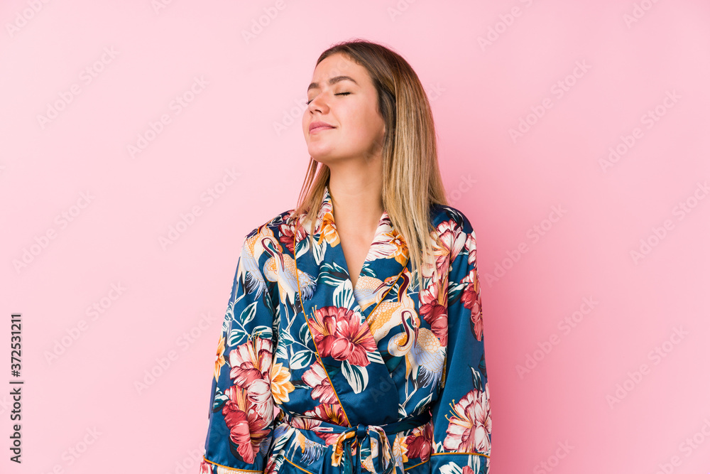Young caucasian woman wearing pajamas dreaming of achieving goals and purposes
