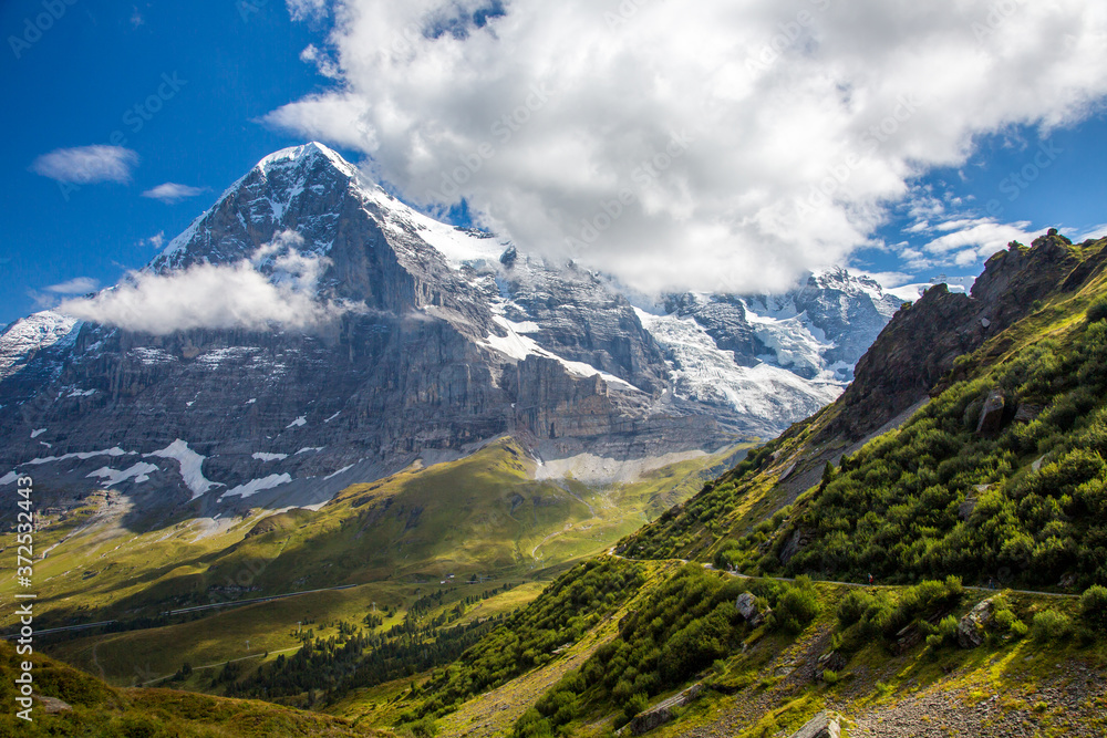 The Eiger trail and The Eiger, a 3,967-metre (13,015 ft) mountain of the Bernese Alps, overlooking Grindelwald and Lauterbrunnen in the Bernese Oberland of Switzerland The Eiger trail and The Eiger, a 3,967-metre (13,015 ft) mountain of the Bernese Alps, overlooking Grindelwald and Lauterbrunnen in the Bernese Oberland of Switzerland