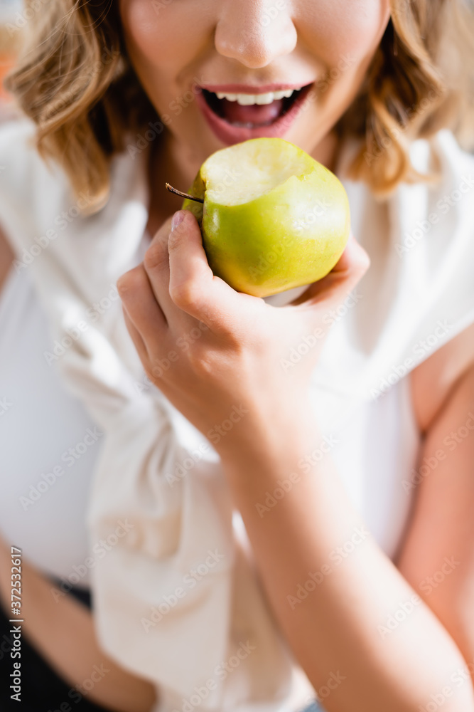 cropped view of young woman eating green apple cropped view of young woman eating green apple