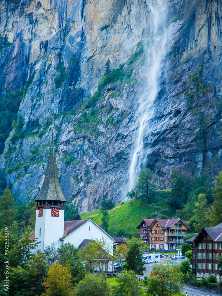 Lauterbrunnen Village Church and Staubbach Falls in Lauterbrunnen, Switzerland.