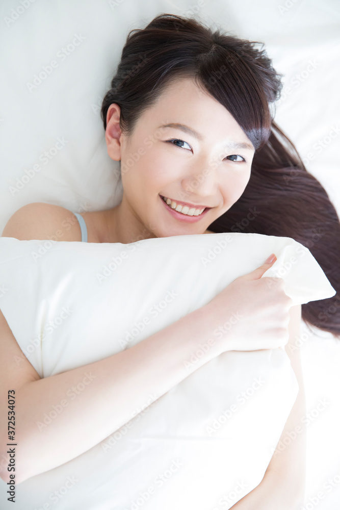 ベッドに寝転ぶ女性 ベッドに寝転ぶ女性