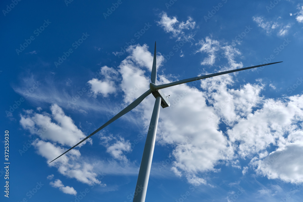Wind turbine on blue sky background, ecological power. Alternative energy source. Wind turbine on blue sky background, ecological power. Alternative energy source.