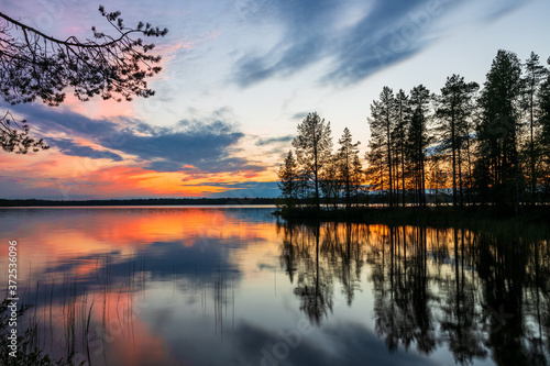 Wallpaper Mural Beautiful summer sunset over finnish lake with silhouette of trees reflecting in water in gold, orange and blue, Finland, Kuusamo, Finland
 Torontodigital.ca