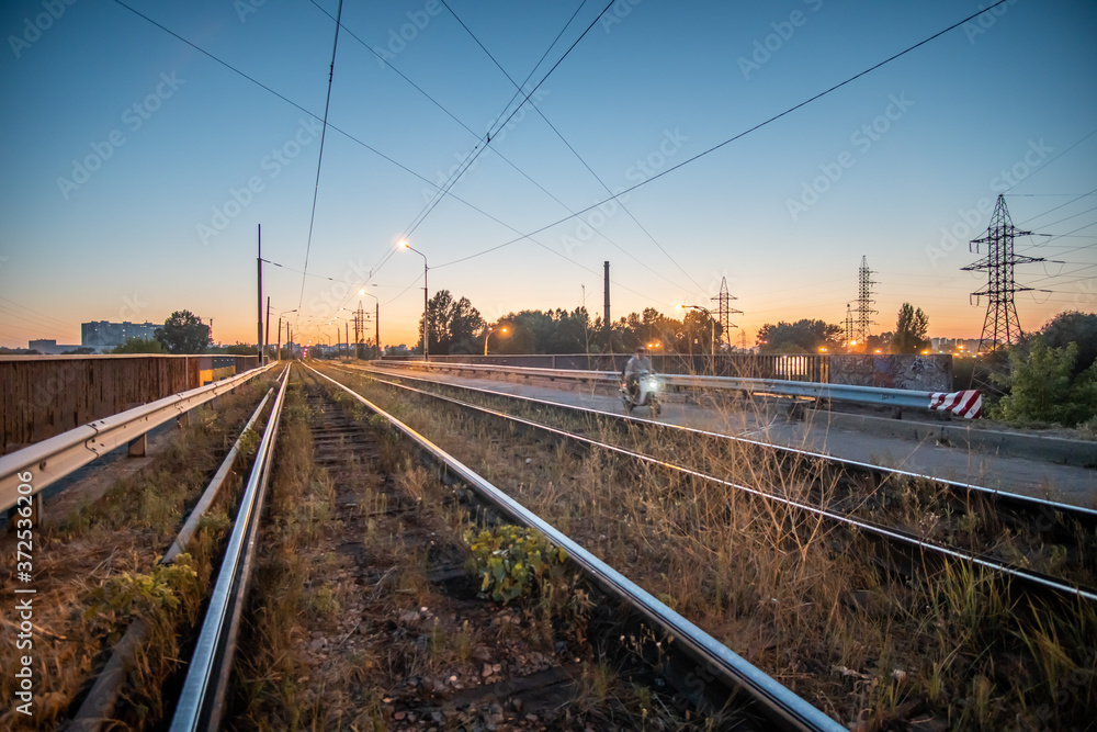 Old tram tracks at dusk in the countryside.