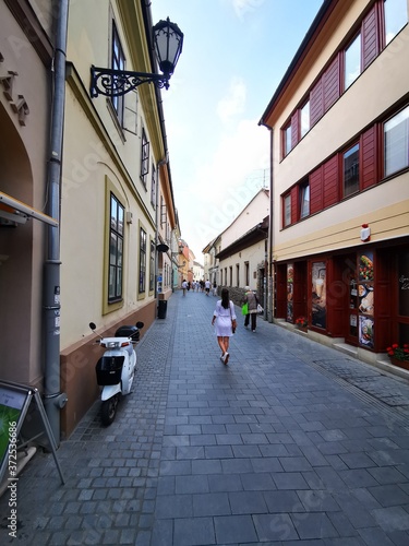 Pretty young girl walks in the beautiful, historic centre of Eger