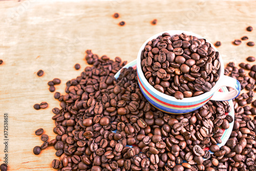 Cup full of coffee beans. Close up. Copy space. Abstract background texture. Coffee beans texture.