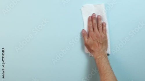 Hand wipes the background with a napkin
