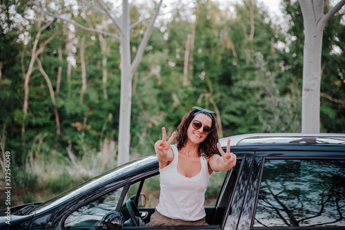 happy young woman in a car. travel and happiness concept