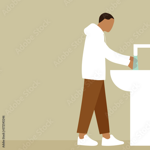 A man washes his hands under the tap with water