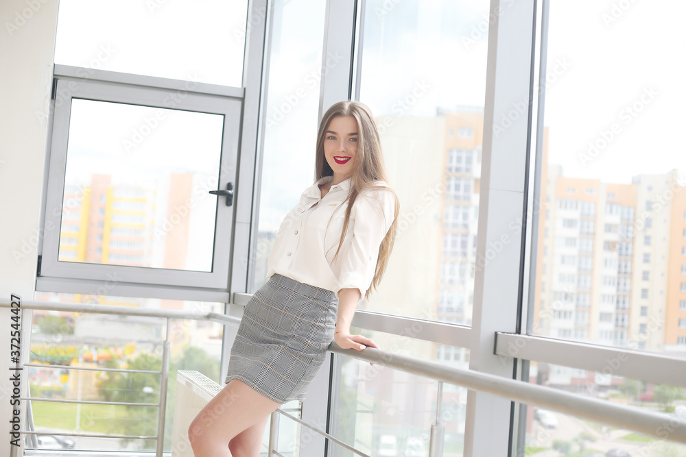 young girl standing near large windows in the office young girl standing near large windows in the office