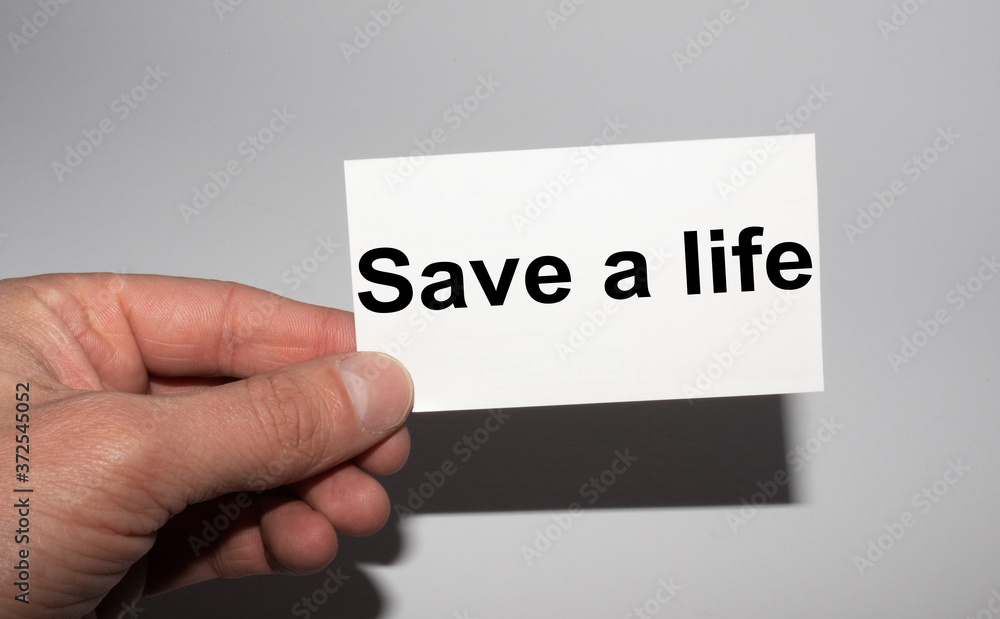Message on the card SAVE A LIFE, in hands of businessman. Message on the card SAVE A LIFE, in hands of businessman.