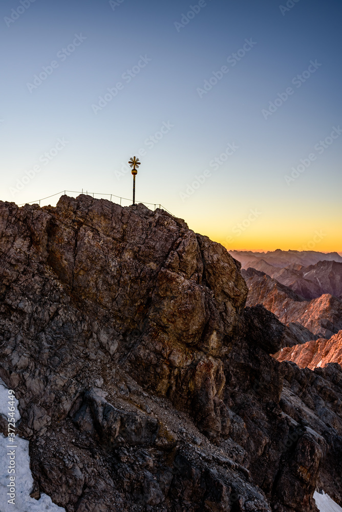Fototapeta premium A beautiful and colorful sunrise on the summit of the highest mountain in Germany, Zugspitze at 2962m. 