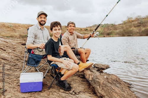 Portrait of male members of three generation family fishing together
