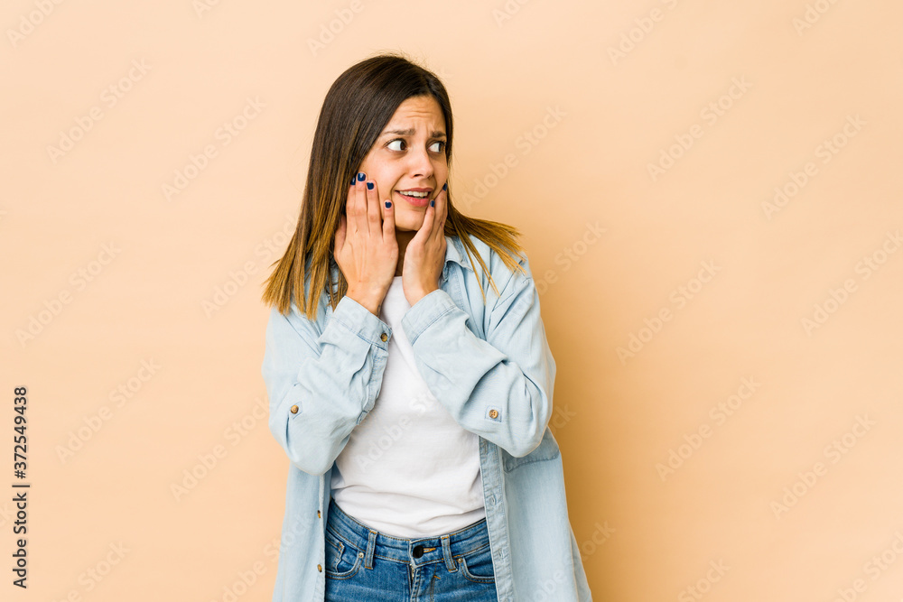 Young woman isolated on beige background scared and afraid. Young woman isolated on beige background scared and afraid.