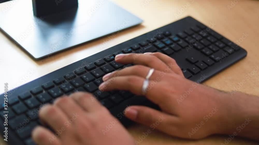A man typing on a keyboard during work from home during the COVID-19 pandemic. A man typing on a keyboard during work from home during the COVID-19 pandemic.