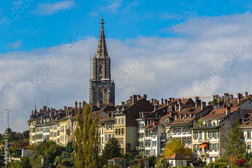 Beautiful view of Bern old town with the tower of Bern Minster (Münster) cathedral on a sunny autumn day with blue sky and cloud, Switzerland