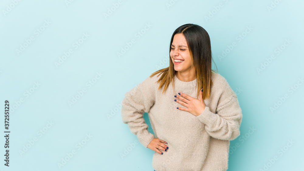 Young woman isolated on blue background laughing keeping hands on heart, concept of happiness. Young woman isolated on blue background laughing keeping hands on heart, concept of happiness.