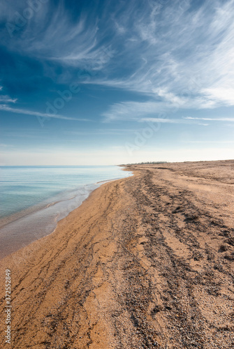 An empty sandy beach stretching towards the horizon.