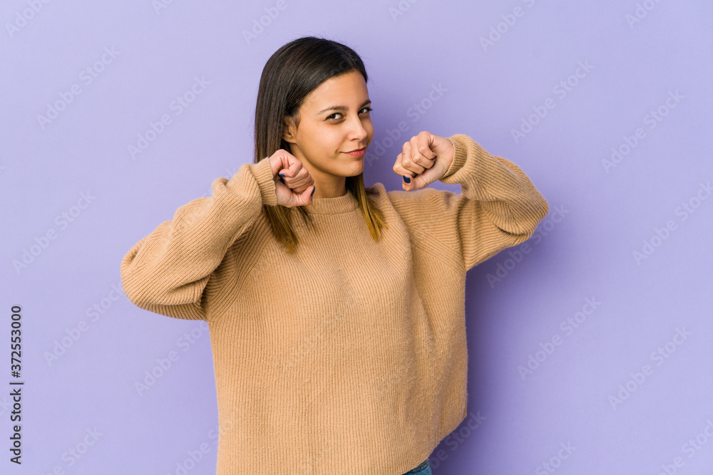 Young woman isolated on purple background throwing a punch, anger, fighting due to an argument, boxing. Young woman isolated on purple background throwing a punch, anger, fighting due to an argument, boxing.