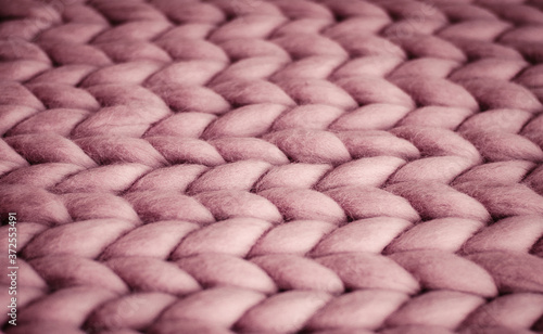 Background. Knitted fabric made of pink Merino wool. Large weave. Pattern of pigtails.
