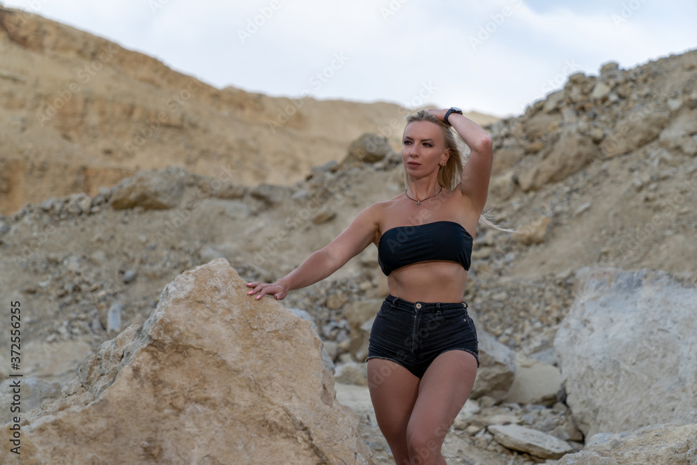 young blonde woman in black shorts and top posing for a photo young blonde woman in black shorts and top posing for a photo