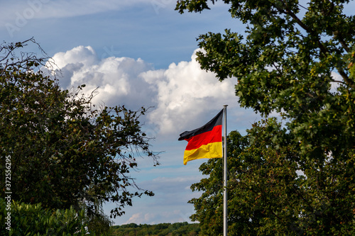 german flag in the wind, fixed at a metal mast