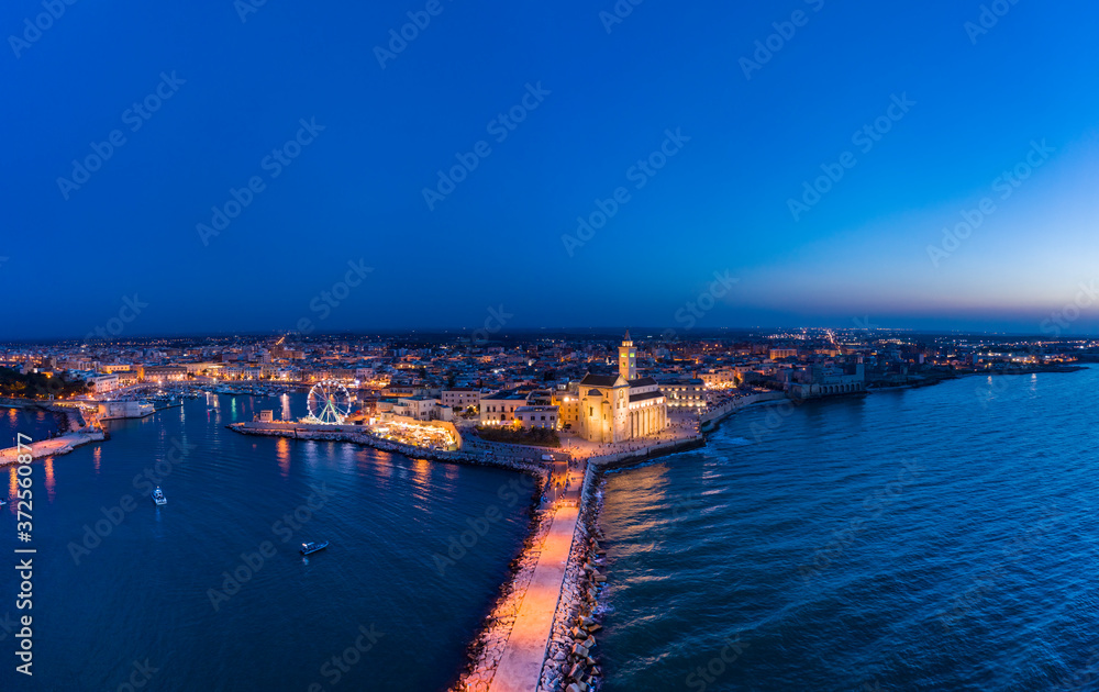 Italy, Puglia, Trani, Pier on sea and Cathedral of San Nicola Pellegrino at night, aerial view Italy, Puglia, Trani, Pier on sea and Cathedral of San Nicola Pellegrino at night, aerial view