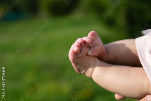 plump baby feet on  green background