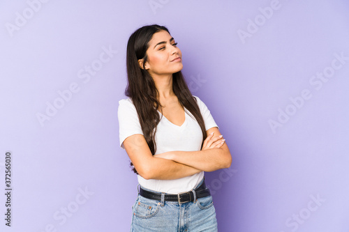 Young indian woman isolated on purple background dreaming of achieving goals and purposes