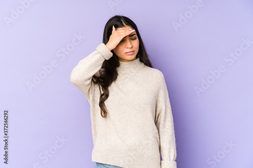 Young indian woman isolated on purple background touching temples and having headache. © Asier