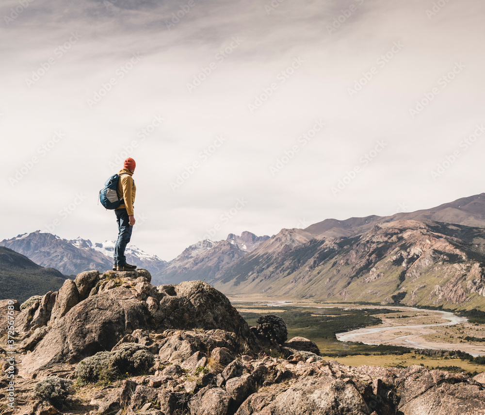 Mature male with backpack standing on rock against sky, Patagonia, Argentina Mature male with backpack standing on rock against sky, Patagonia, Argentina