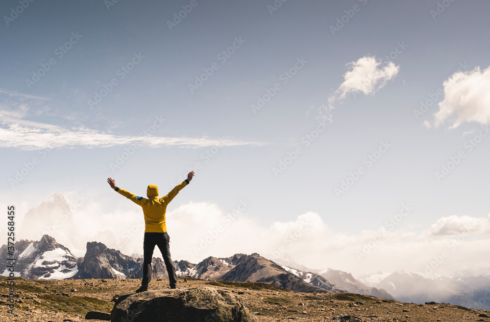 Man with arms outstretched looking at landscape against sky, Patagonia, Argentina Man with arms outstretched looking at landscape against sky, Patagonia, Argentina