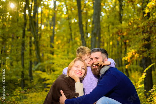 Young parents and children having picnic and relaxing together on an autumns sunny day. Happy family. Happy couple with kid outdoors. Family with boy. Happy family outdoors. © Svitlana