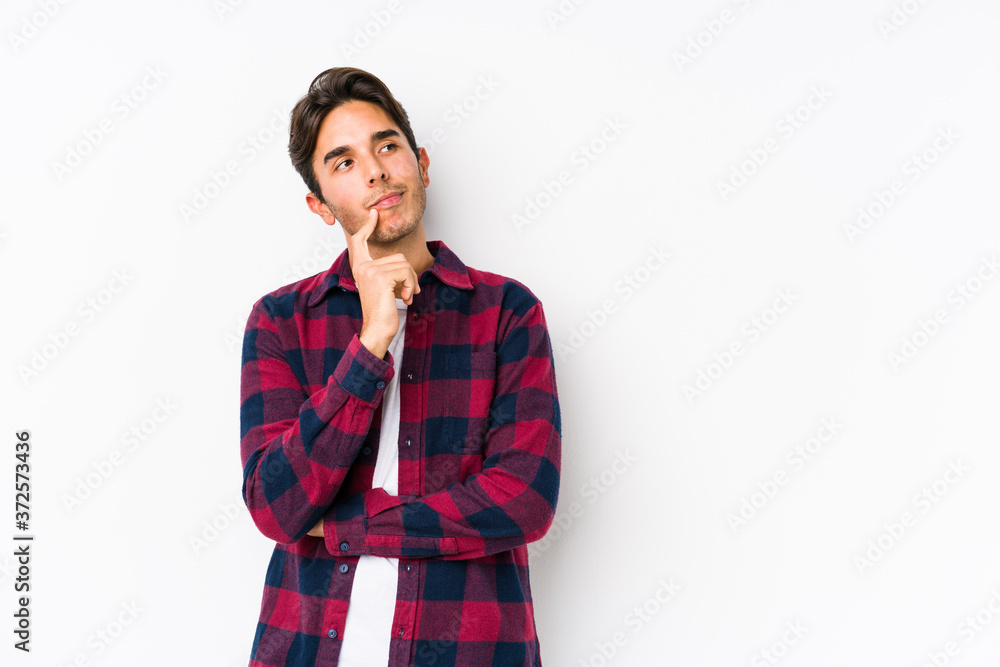 Young caucasian man posing in a pink background isolated looking sideways with doubtful and skeptical expression. Young caucasian man posing in a pink background isolated looking sideways with doubtful and skeptical expression.