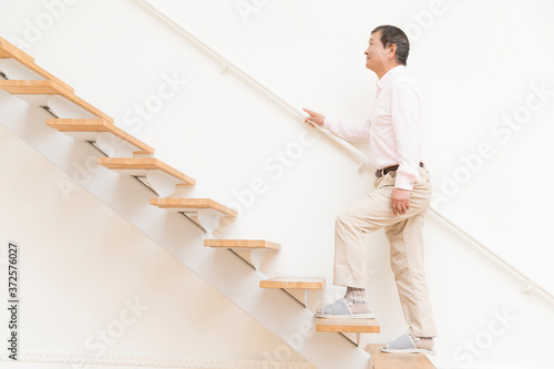 階段を上るシニア男性