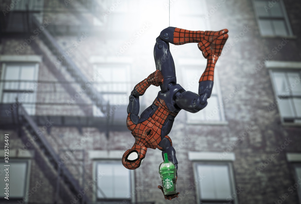 Obraz premium NEW YORK USA, AUGUST 19 2020: superhero Spiderman hanging upside down from a web with a Starbucks Frappuccino - Hasbro Legends action figure